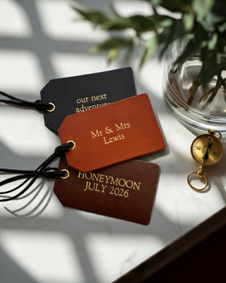 leather luggage tag with gold writing.