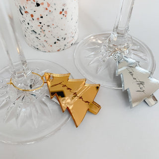 Christmas table with gold coaster, wine glass charm and a wine glass filled with bubbles.