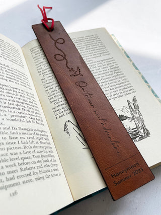 on to our next adventure engraved onto a tan bookmark with a plain laser etched on it.