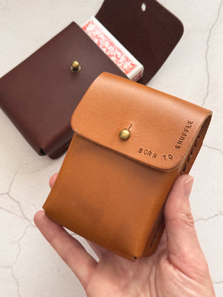 Tan and Brown leather deck of card holders held by a hand with 'Born to Shuffle' text on a light background