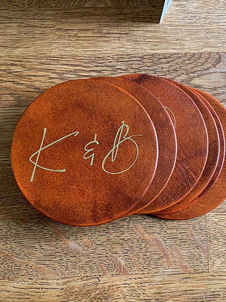 Tan leather coasters with initials, perfect for anniversary gift.