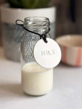 Minimalist white leather pantry tags with hand-stamped labels for kitchen storage. Rustic and stylish labels with black cord, ideal for home organisation and pantry décor