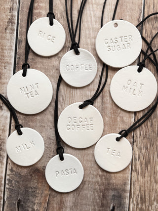 Minimalist white leather pantry tags with hand-stamped labels for kitchen storage. Rustic and stylish labels with black cord, ideal for home organisation and pantry décor