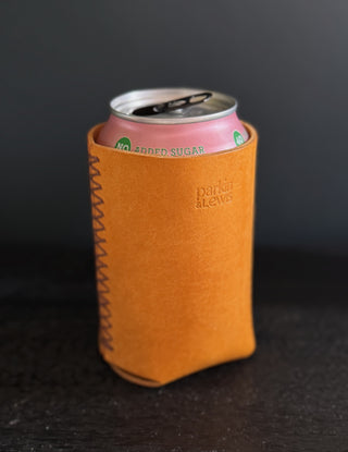 Yellow can cooler with a pink can inside on a dark background